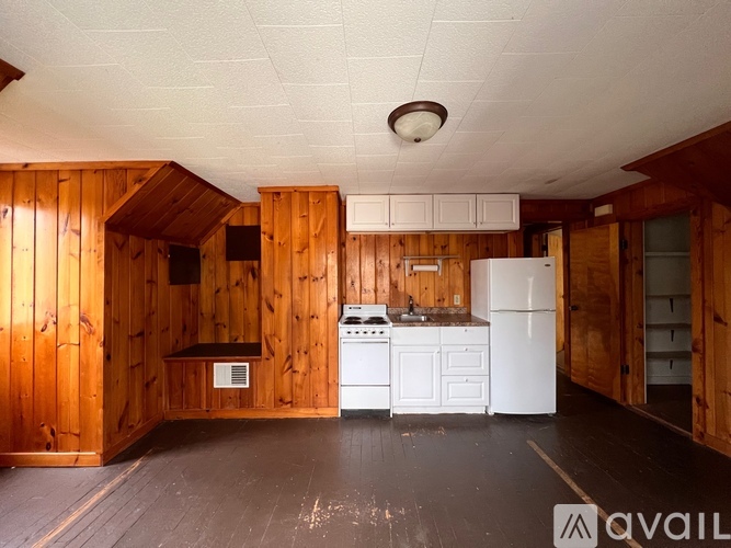 A kitchen with wooden walls and white appliances.