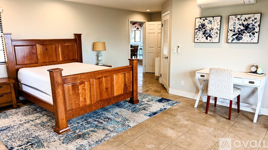 A bedroom with a bed, desk, and chair.
