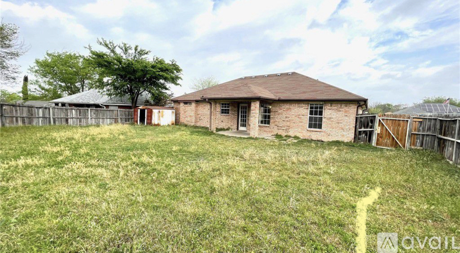 A house with a fence and a tree in the background.