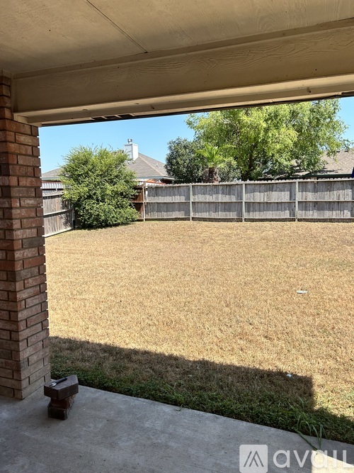 A backyard with a fence and trees visible through a window.