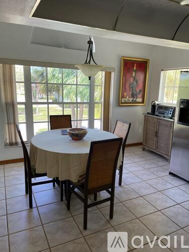 A dining room with a round table and chairs.