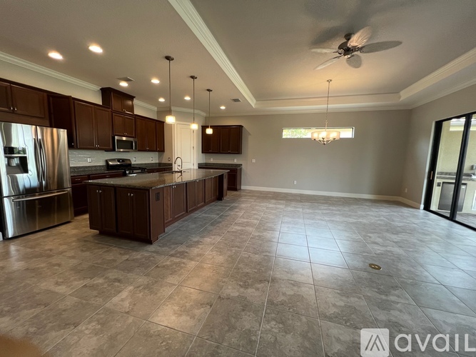 A spacious kitchen with dark wood cabinets and a central island.