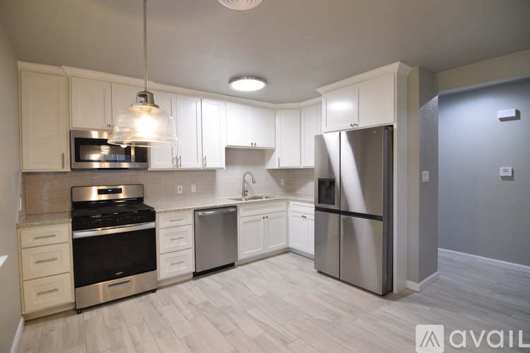 A kitchen with white cabinets and stainless steel appliances.