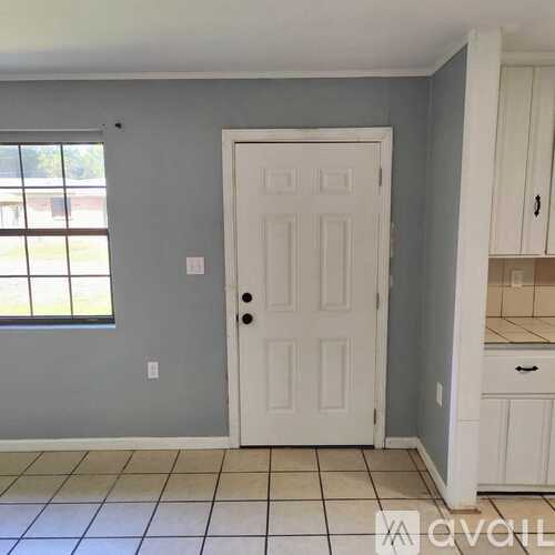 A white door is in a room with grey walls.