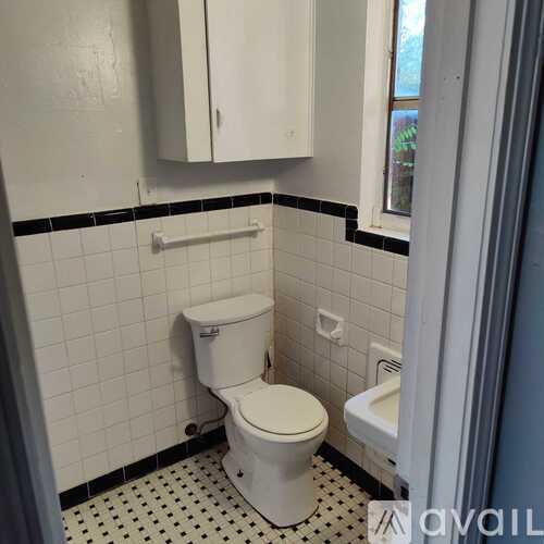 A white toilet in a bathroom with black and white tiles.