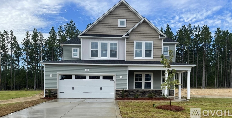 A two-story house with a garage is available for sale.