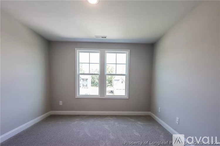 A room with a window showing a view of other buildings.
