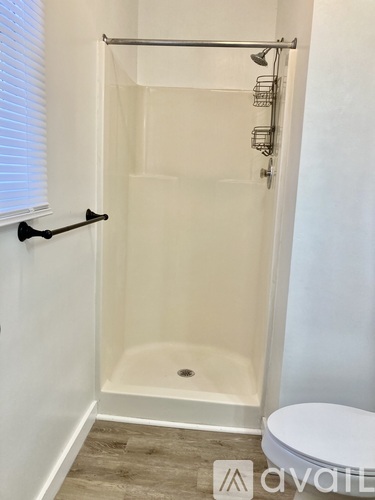 A white bathroom with a walk-in shower and toilet.