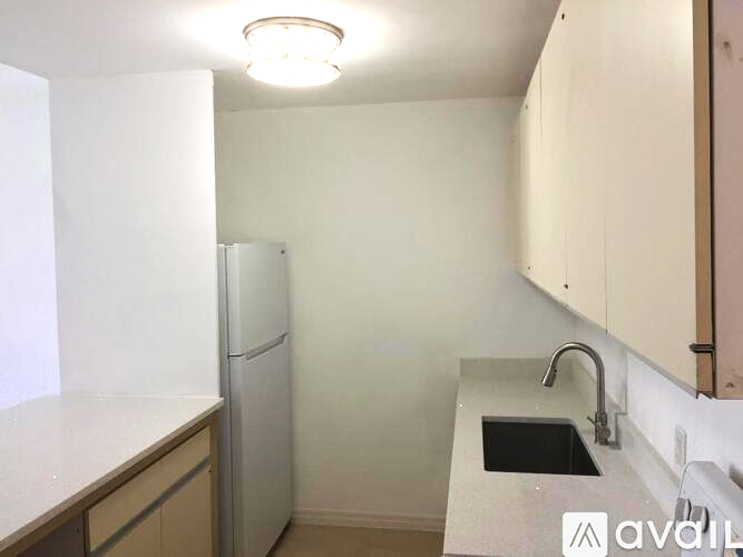 A kitchen with a white fridge and a sink.