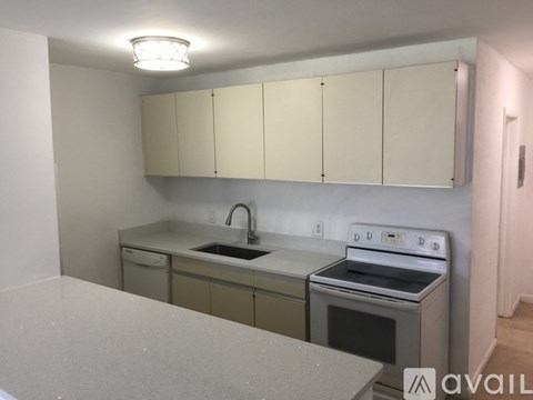 A kitchen with white cabinets and a stove top oven.