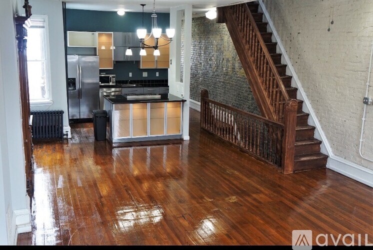 A wooden staircase with a metal railing leads up to a second floor.