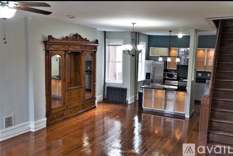 A room with a wooden floor and a large wooden cabinet.