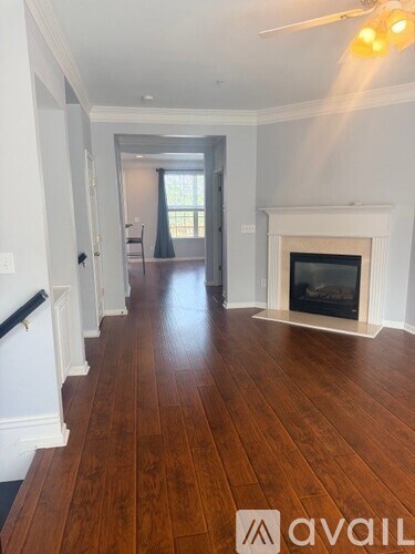 A living room with a fireplace and wood flooring.
