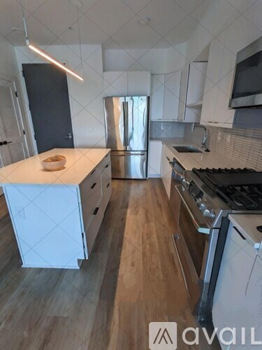 A kitchen with a white countertop and wooden cabinets.