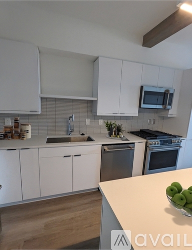 A kitchen with white cabinets and a wooden countertop.