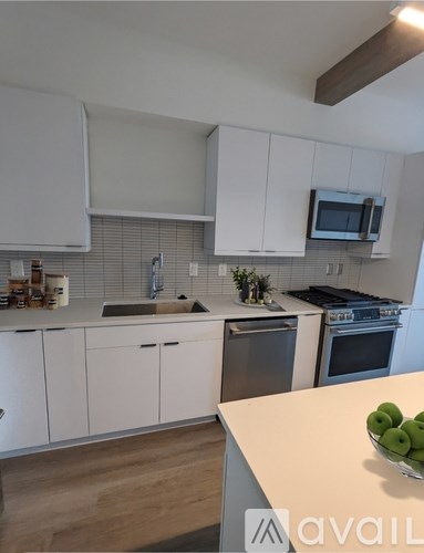 A kitchen with white cabinets and a wooden countertop.