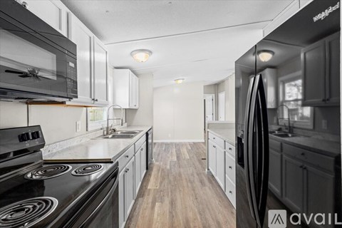A modern kitchen with a black stove top oven and a black refrigerator.