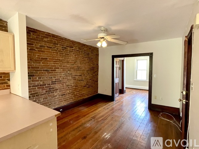 A room with a brick wall and wooden flooring.