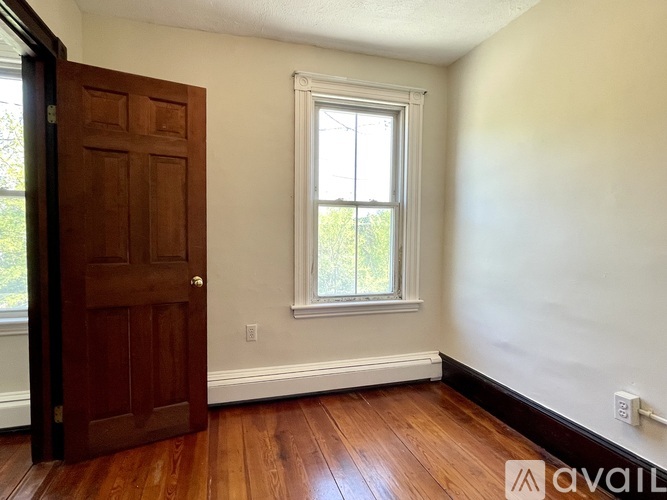 A room with a wooden door and a window.