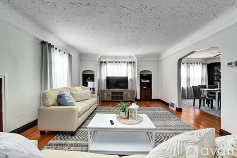 A living room with a couch, a coffee table, and a television.