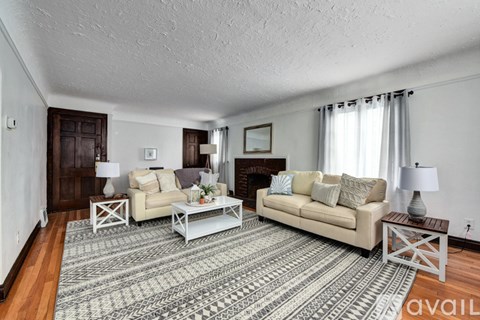 A living room with a rug, two couches, and a coffee table.