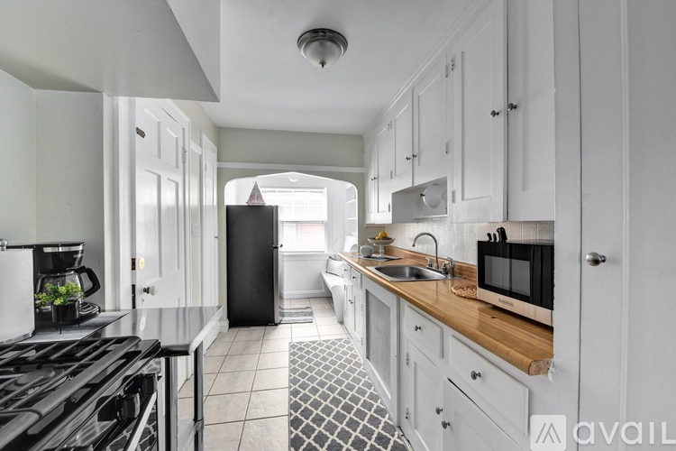 A kitchen with a black stove top oven and white cabinets.