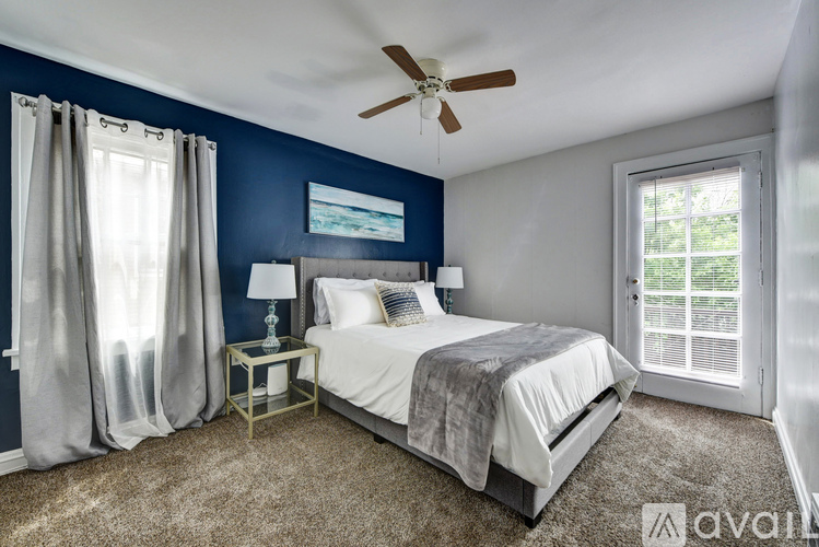 A bedroom with a bed, nightstand, and a ceiling fan.