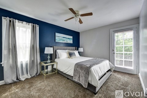 A bedroom with a bed, nightstand, and a ceiling fan.
