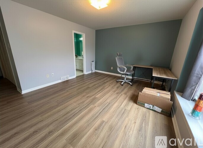 A room with wooden flooring and a white chair.