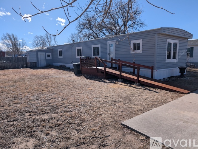 A row of mobile homes with a wooden fence in front.