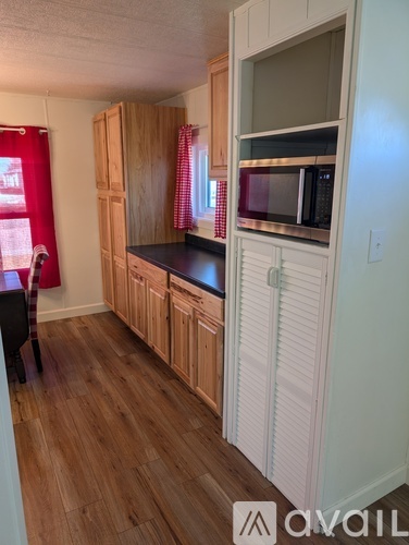 A kitchen with wooden cabinets and a microwave.