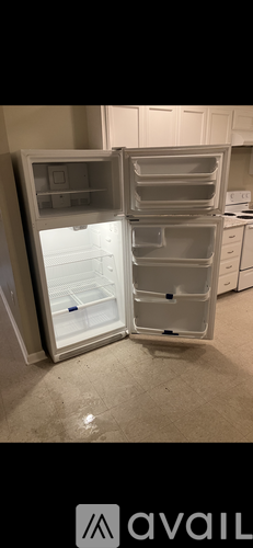 A white refrigerator with its door open in a kitchen.