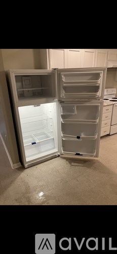 A white refrigerator with its door open in a kitchen.