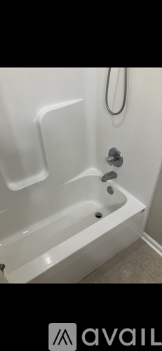 A white bathtub with a silver faucet and a silver shower head.