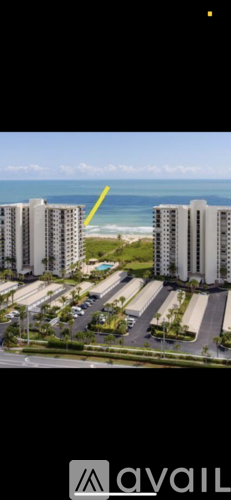 A yellow arrow points to a building on the beachfront.