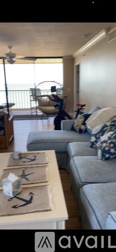 A living room with a grey couch and a coffee table with a bag on it.