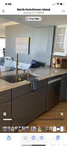 A modern kitchen with dark cabinets and a marble countertop.