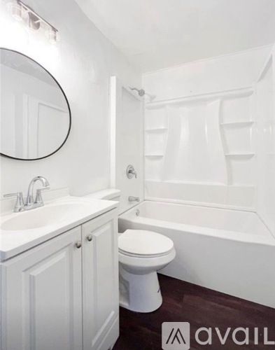 A white bathroom with a toilet, sink, and bathtub.