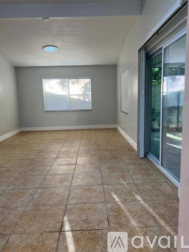 A room with tiled flooring and a window letting in sunlight.
