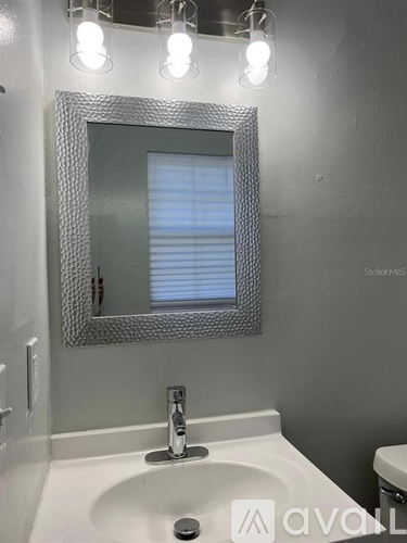 A bathroom with a white sink and a mirror above it.