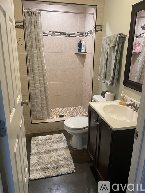 A bathroom with a toilet, sink, and shower.