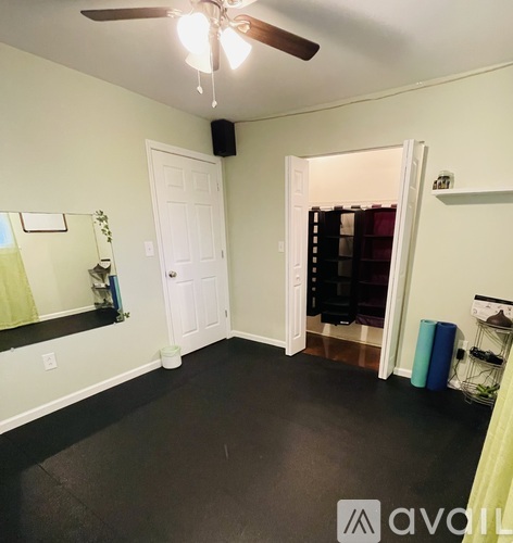 A room with a ceiling fan and a doorway leading to another room.