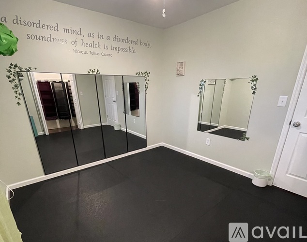 A room with a quote on the wall and mirrors on the wall.