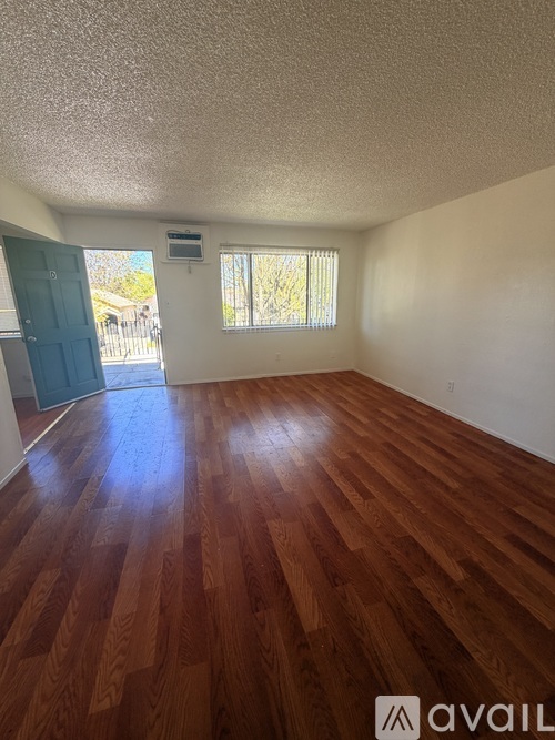 A room with wooden flooring and a window.