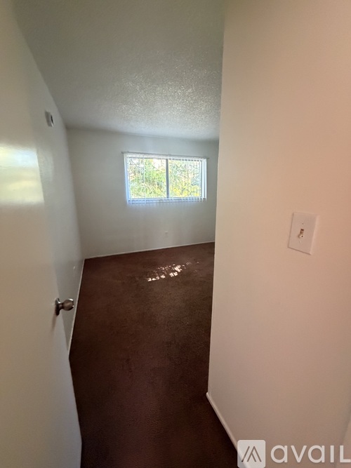 A room with a brown floor and a window.