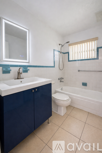 A bathroom with blue cabinets and a white sink.