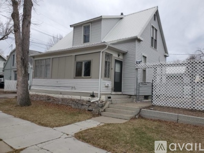 A two-story house with a white picket fence in front.