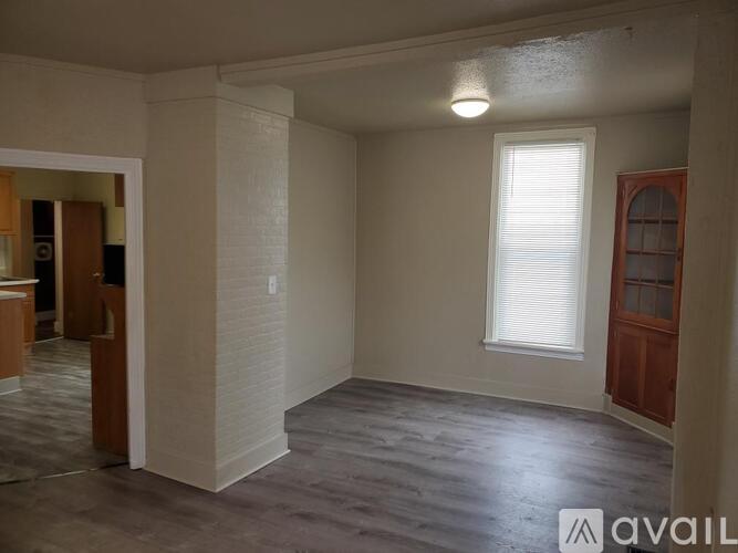 A room with a window and a door leading to another room.