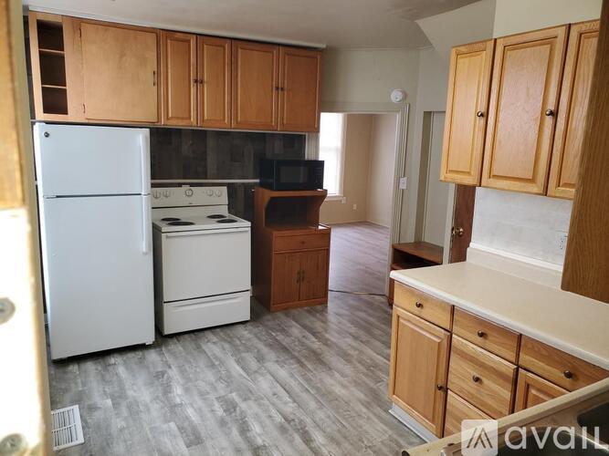 A kitchen with wooden cabinets and a white fridge.