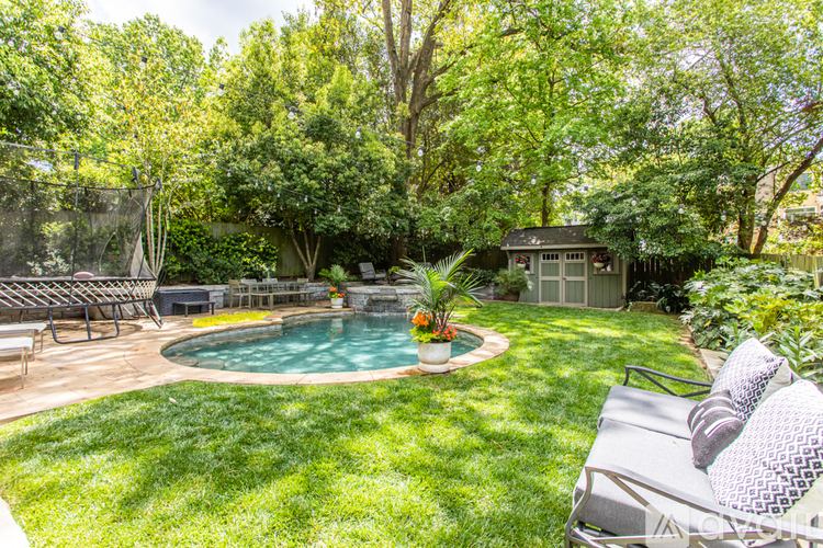 A backyard with a pool and a patio.